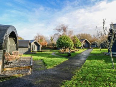 An outdoor area with cabins and a pathway at Garden Lodge 4 in Swansea