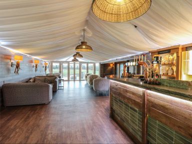 A bar area with seating and glass doors at Garden Lodge 7 Swansea