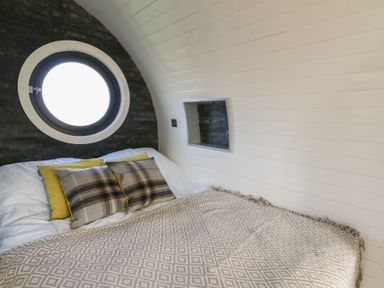A bedroom with a bed and pillows at Garden Lodge 10 Swansea