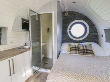 A bedroom with a bed and bathroom area at Garden Lodge 10 in Swansea