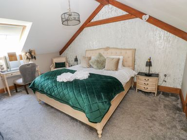 A bedroom with a bed, bedside table and a chair at Rose Apartment, Old Walls, Llanrhidian, Gower