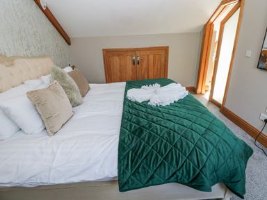 A bedroom with a bed and wardrobe at Rose Apartment in Old Walls, Llanrhidian, Gower