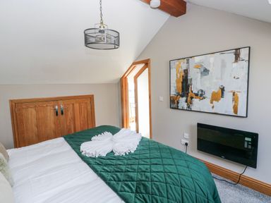 A bedroom with a bed and a door leading outside at Rose Apartment Old Walls, Llanrhidian, Gower