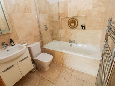 A bathroom with a bathtub, sink and toilet at Rose Apartment, Old Walls, Llanrhidian, Gower