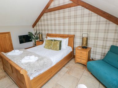 A bedroom with a bed and nightstand at Willow Apartment in Oldwalls, Llanrhidian, Gower