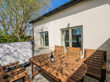 An outdoor seating area with a table and chairs at Ivy Cottage, Oldwalls, Llanrhidian, Gower