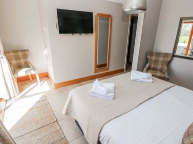 A bedroom with towels on the bed at Ivy Cottage in Oldwalls, Llanrhidian, Gower