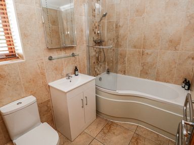 A bathroom with a bath and sink at Ivy Cottage in Oldwalls, Llanrhidian, Gower