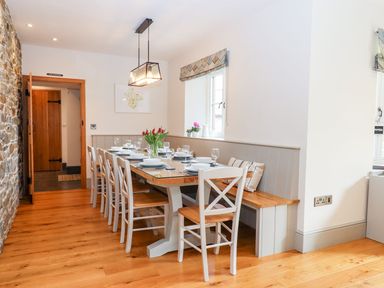 A dining room with a table and chairs at Knowle House Okehampton