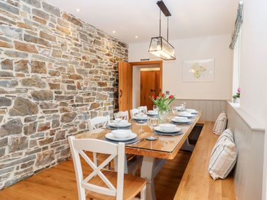 A dining room with a wooden table and chairs at Knowle House in Okehampton