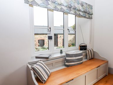 A sitting room with a bench seat and radio at Knowle House Okehampton