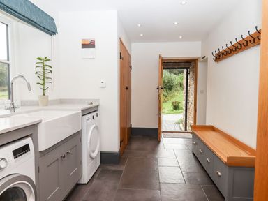 A utility room with sink and washing machine at Knowle House in Okehampton