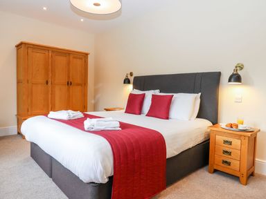 A bedroom with a bed and wardrobe at Knowle House in Okehampton