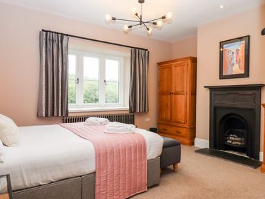 A bedroom with a bed and wardrobe at Knowle House Okehampton