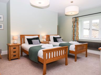 A bedroom with two single beds and a window at Knowle House in Okehampton