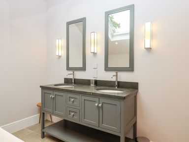 A bathroom with a double vanity and mirrors at Knowle House in Okehampton