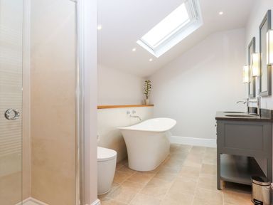 A bathroom with a bathtub, shower, toilet, and sink at Knowle House in Okehampton