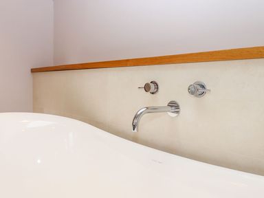 A bathtub with faucets and knobs at Knowle House in Okehampton