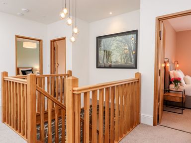 A hallway with a wooden staircase at Knowle House Okehampton