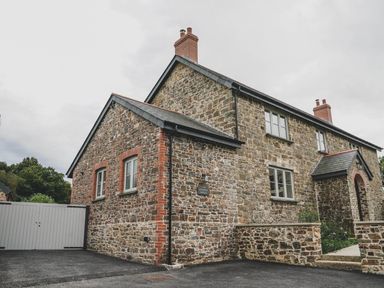 A stone house with windows and a garage at Knowle House in Okehampton