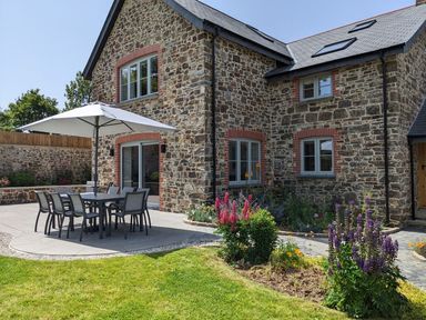 An outdoor dining area with tables and chairs at Knowle House Okehampton