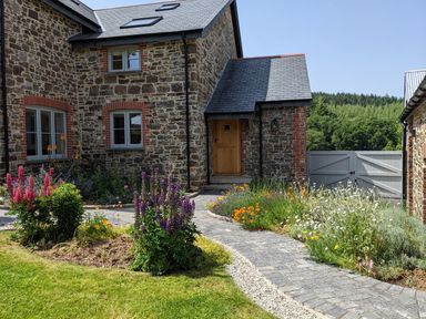 A house with a pathway and flowers at Knowle House in Okehampton