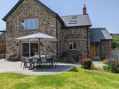 A garden with a table and chairs near the house at Knowle House Okehampton