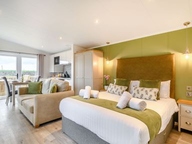 A bedroom with a bed and seating area at Pear Tree Spa in Carlton Miniott near Thirsk