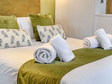 A bedroom with a bed and decorative cushions at Pear Tree Spa in Carlton Miniott near Thirsk