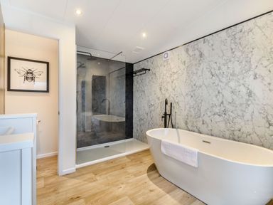 A bathroom with a bathtub and shower at Pear Tree Spa (Pet) Carlton Miniott near Thirsk