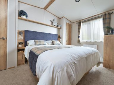 A bedroom with a bed and bedside table at Juniper Waterside Spa Carlton Miniott near Thirsk