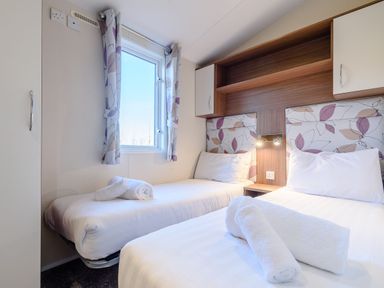 A bedroom with two beds and a window at Alder Spa in Carlton Miniott near Thirsk