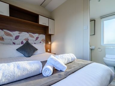 A bedroom with a bed and towels at Alder Spa Carlton Miniott near Thirsk