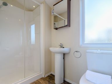 A bathroom with a shower, sink, and toilet at Alder Spa in Carlton Miniott near Thirsk