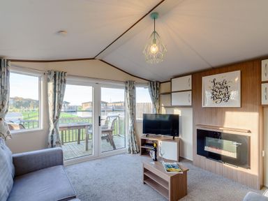 A living room with a television and a fireplace at Alder Spa in Carlton Miniott near Thirsk