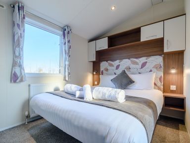 A bedroom with a bed and window at Alder Waterside Spa Carlton Miniott near Thirsk