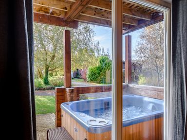 A hot tub with a view of the garden at Birch Waterside Spa in Carlton Miniott near Thirsk