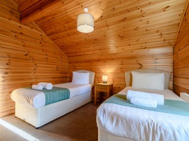 A bedroom with two single beds and a bedside table at Birch Waterside Spa Carlton Miniott near Thirsk