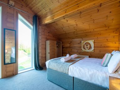 A bedroom with a bed and a mirror at Birch Waterside Spa in Carlton Miniott near Thirsk