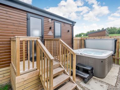 An outdoor area with a hot tub and wooden stairs at Cedar Spa Carlton Miniott near Thirsk