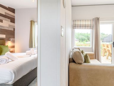 A bedroom with a bed and sofa at Cedar Spa Carlton Miniott near Thirsk