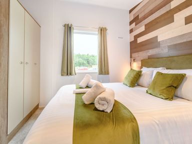 A bedroom with a bed and curtains at Cedar Spa Carlton Miniott near Thirsk