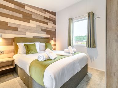 A bedroom with a bed and curtains at Cedar Spa in Carlton Miniott near Thirsk