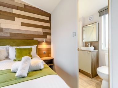 A bedroom with a bed and an attached bathroom at Cedar Spa (Pet) Carlton Miniott near Thirsk