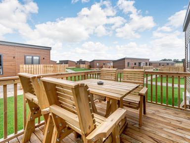 An outdoor seating area with wooden furniture at Kinder Spa Carlton Miniott near Thirsk