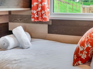 A bedroom with a bed, pillows, towels, and a window at Kinder Spa in Carlton Miniott near Thirsk