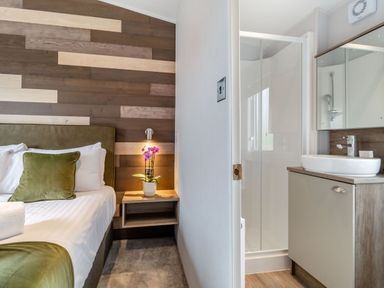 A bedroom with a bed and an attached bathroom at Kinder Spa (Pet) Carlton Miniott near Thirsk