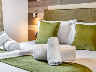 A bedroom with bedding and towels at Kinder Spa (Pet) Carlton Miniott near Thirsk