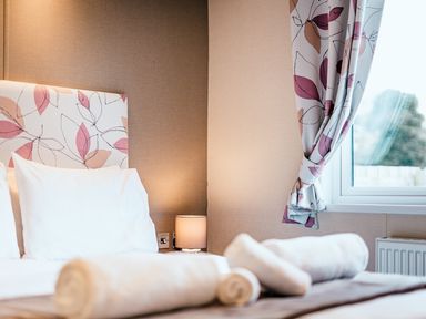 A bedroom with a bed and lamp at Oak Waterside Spa Carlton Miniott near Thirsk