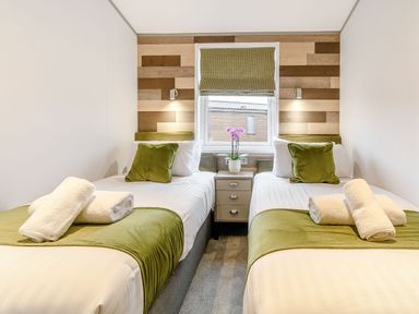 A bedroom with twin beds and a window at Oak Waterside Spa Carlton Miniott near Thirsk